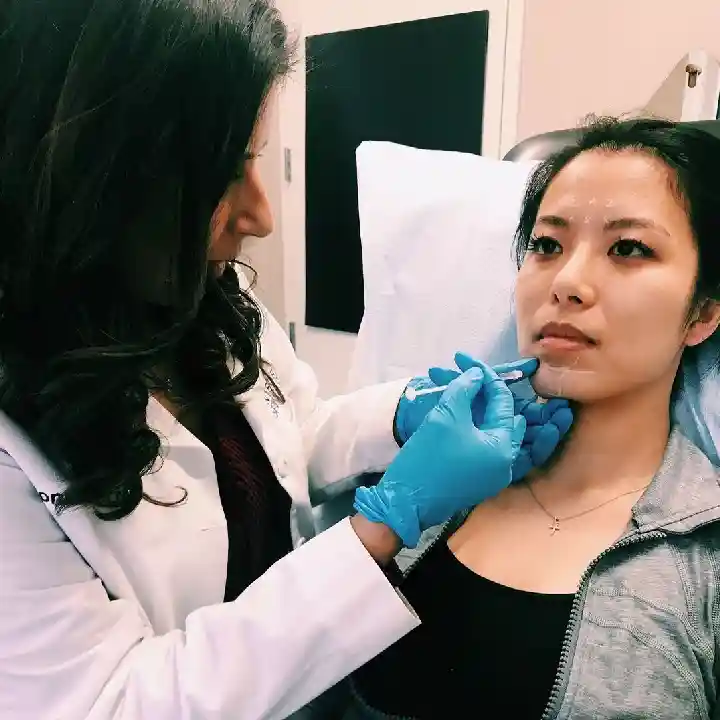 A woman receiving a Botox injection from Dr. Lal, enhancing her appearance and rejuvenating her skin.