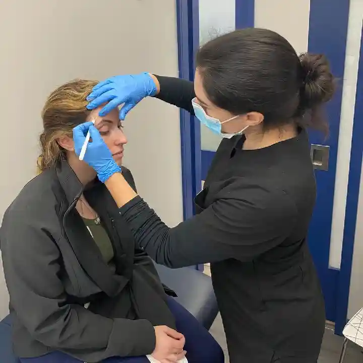 A women getting prepared for her Botox procedure and the Injector shows her where the injections will be placed