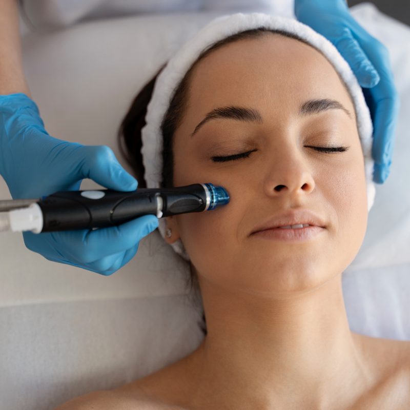 Close-up of woman getting facial hydro microdermabrasion peeling treatment. Female at cosmetic beauty spa clinic. Hydra vacuum cleaner. Cosmetology concept